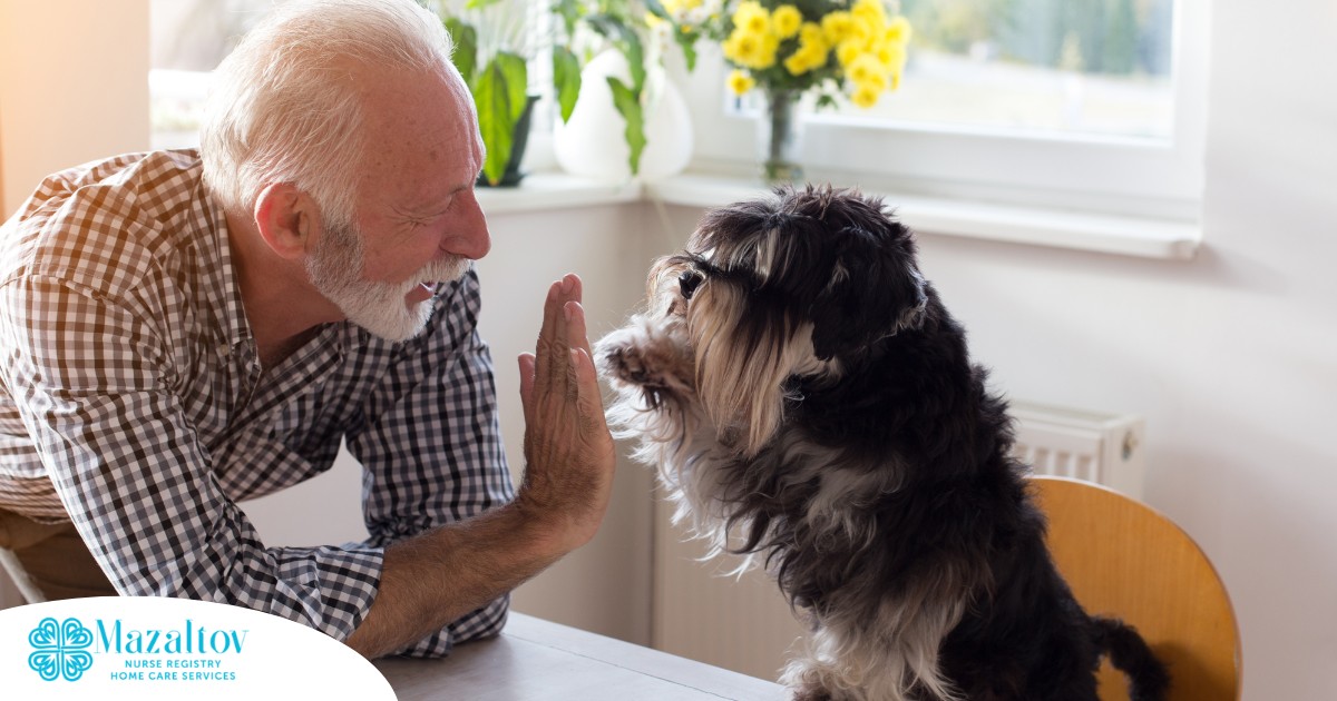 A senior man “high-fives” his pet dog, showing the type of close relationship professional caregivers should be aware of when caring for clients.