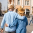 2 older adults hug while on vacation representing the successful outing that can still happen while caring for elderly loved ones.